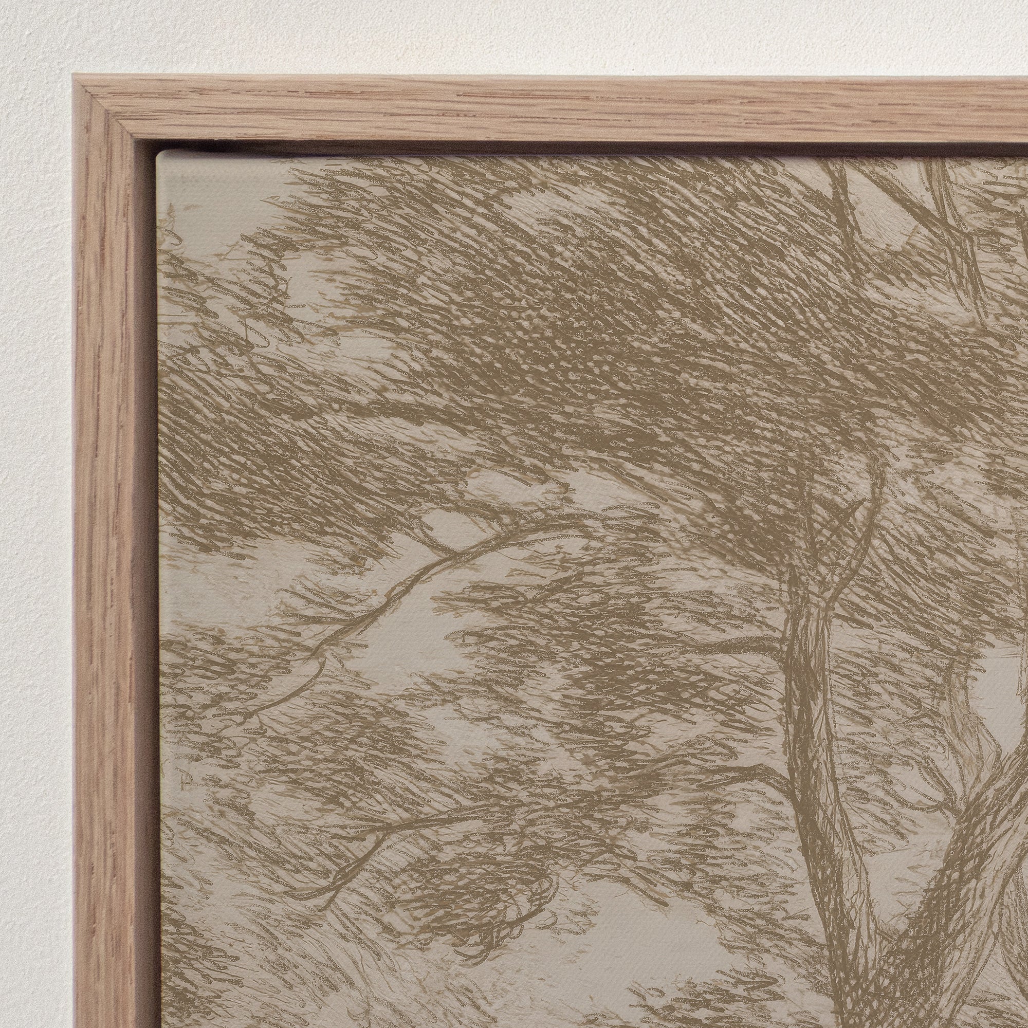 A close-up of framed wall art showing a sketch-style tree and branch design in warm taupe and beige tones, bordered by a light natural wood frame against a white wall.