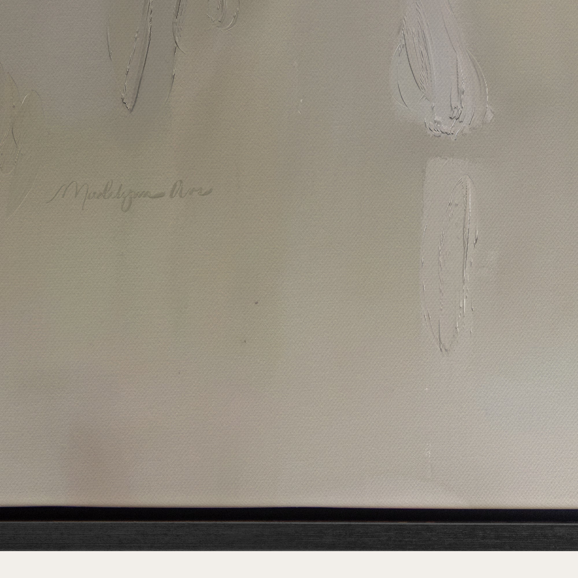 Close-up of a signature on a textured beige surface with a black border. 