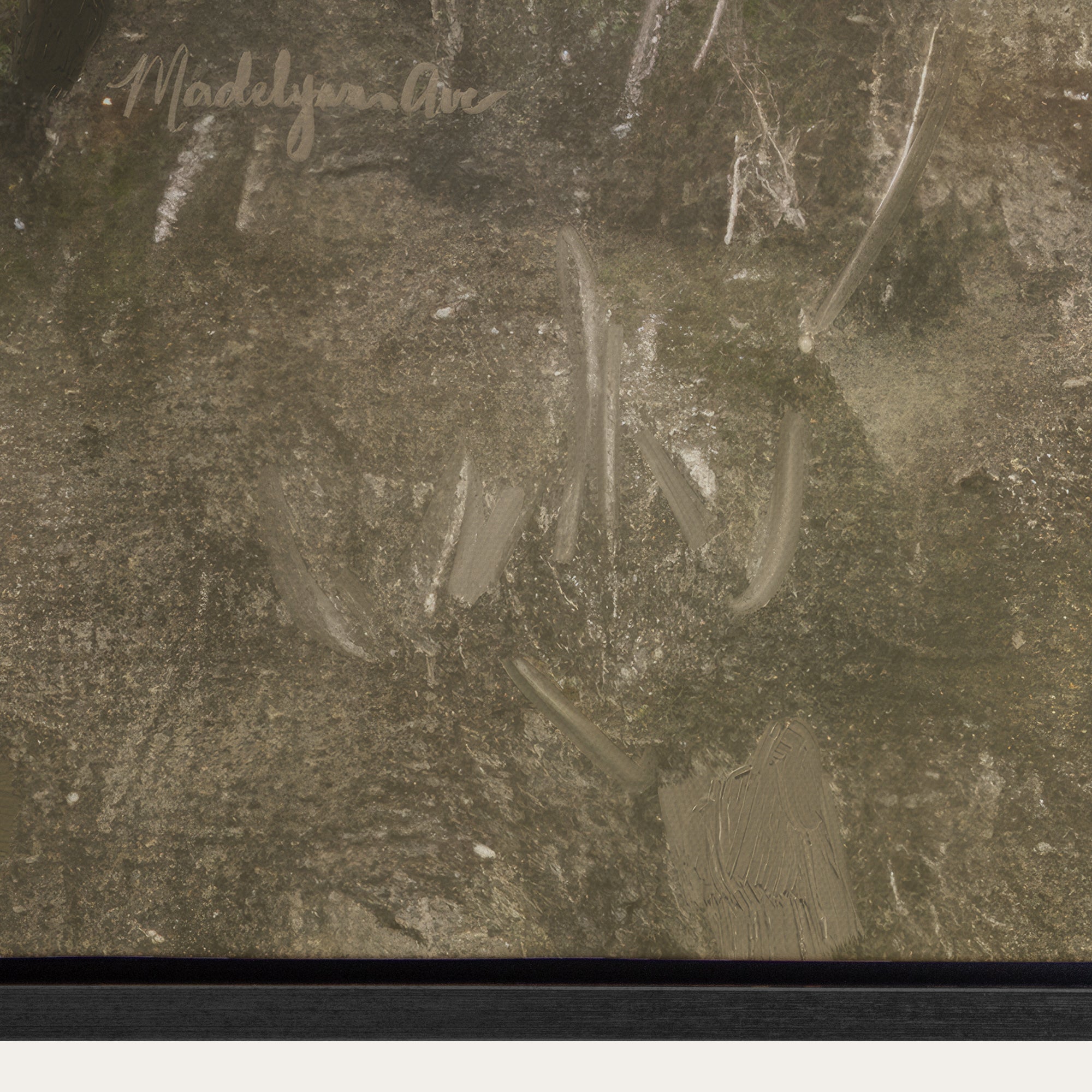 Close-up of a textured surface with a signature in the top left corner. 