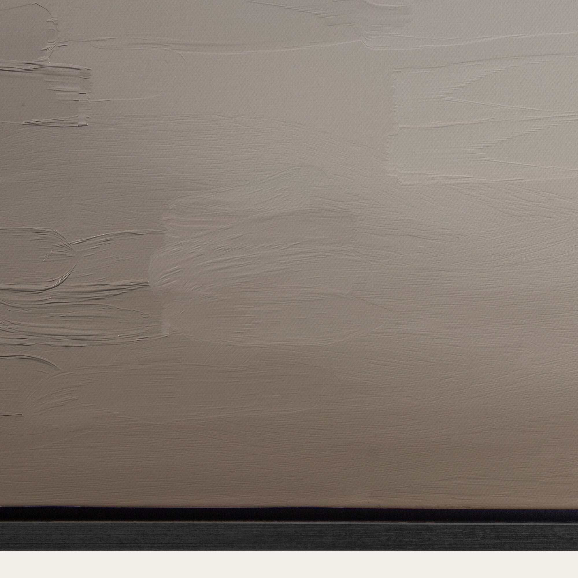Textured beige wall with a black baseboard 