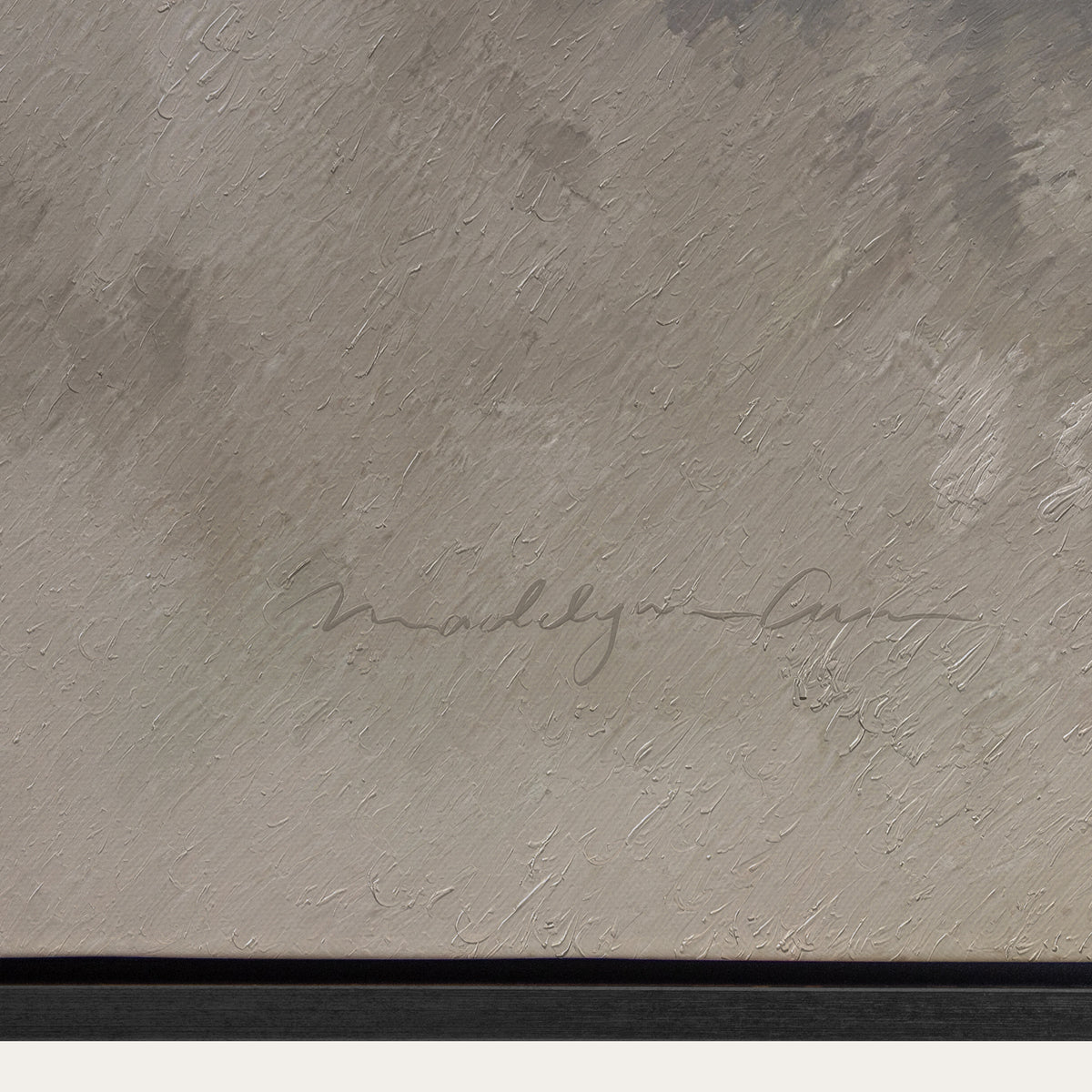 Textured gray surface with a signature in the center 