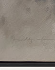 textured gray surface with a signature in the center 