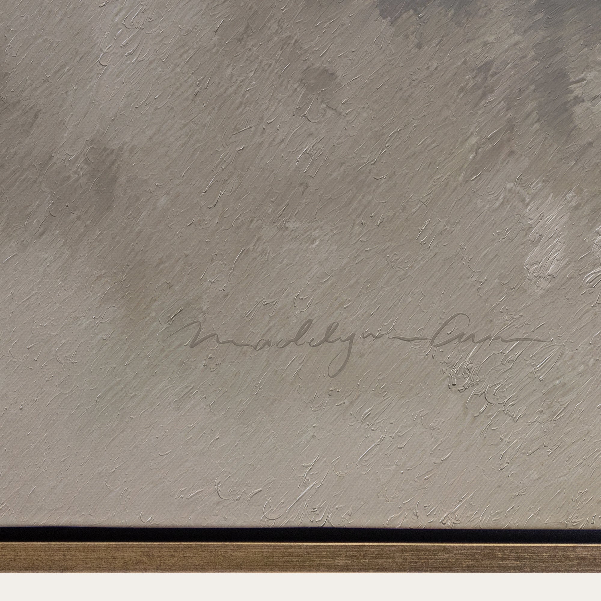 Textured beige surface with a signature and black border 