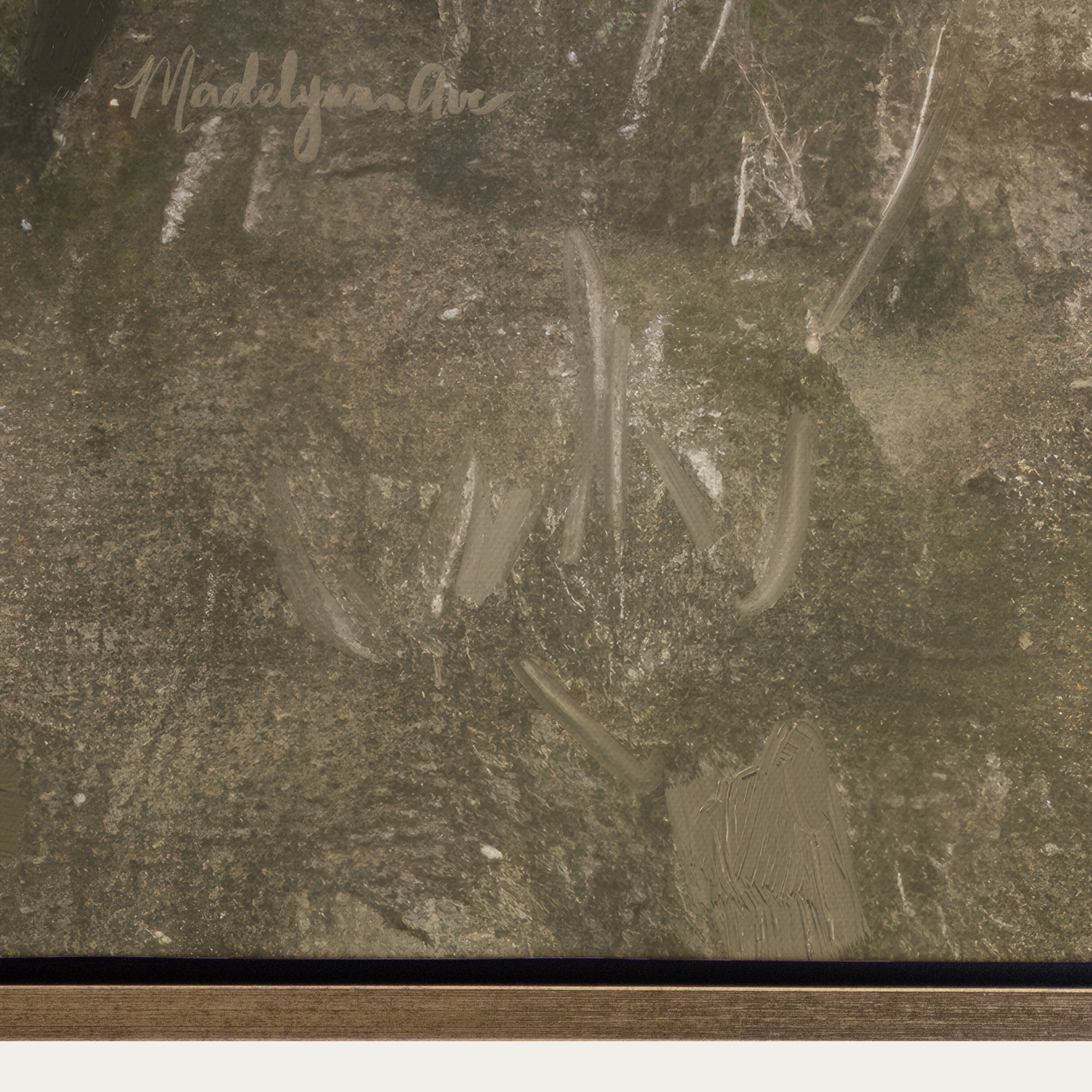 Close-up of a textured surface with a signature in the top left corner. 