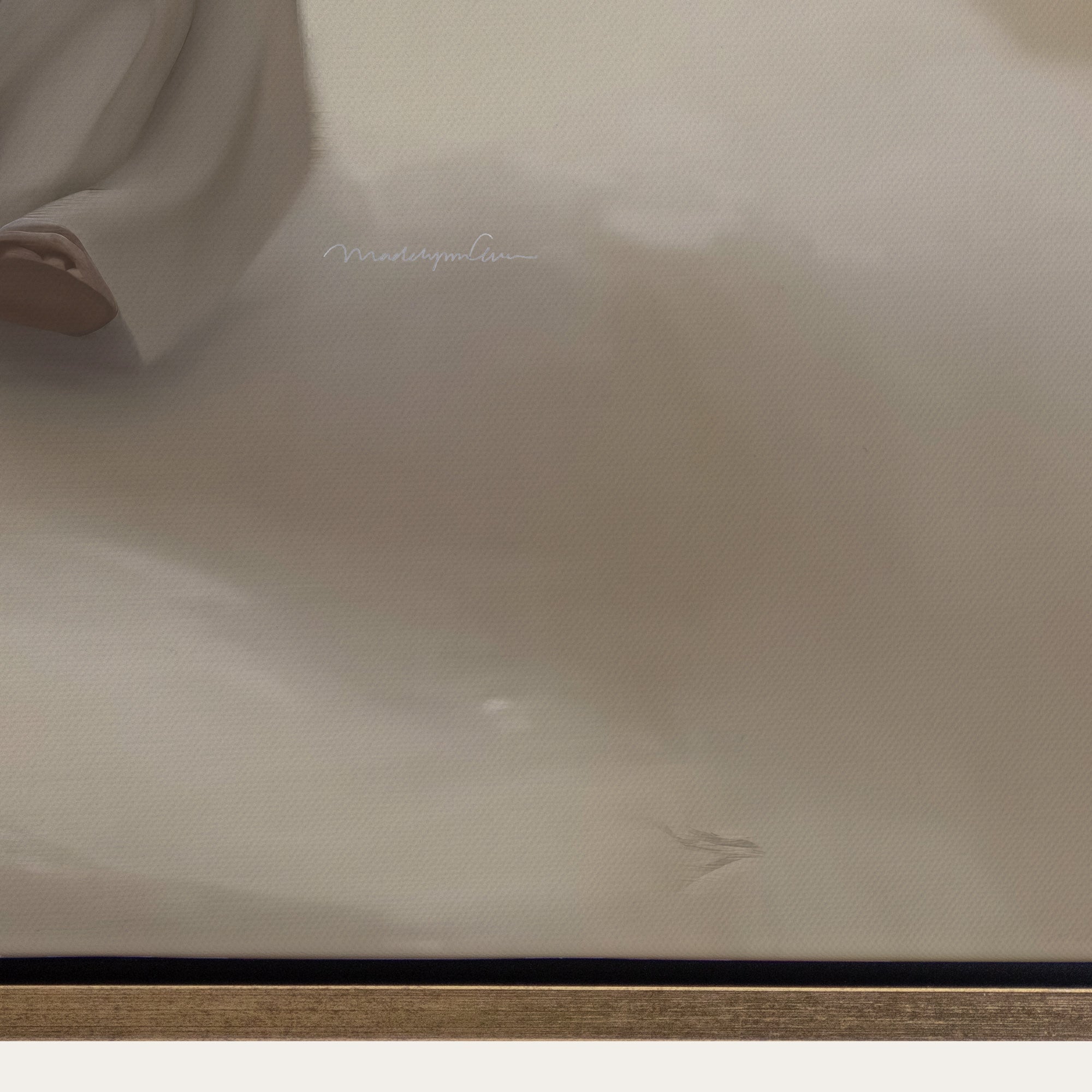 Close-up of a beige fabric surface with a brand logo. 