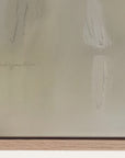 close-up of a textured beige surface with a signature at the bottom left corner. 