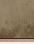 textured brown surface with a signature at the bottom 