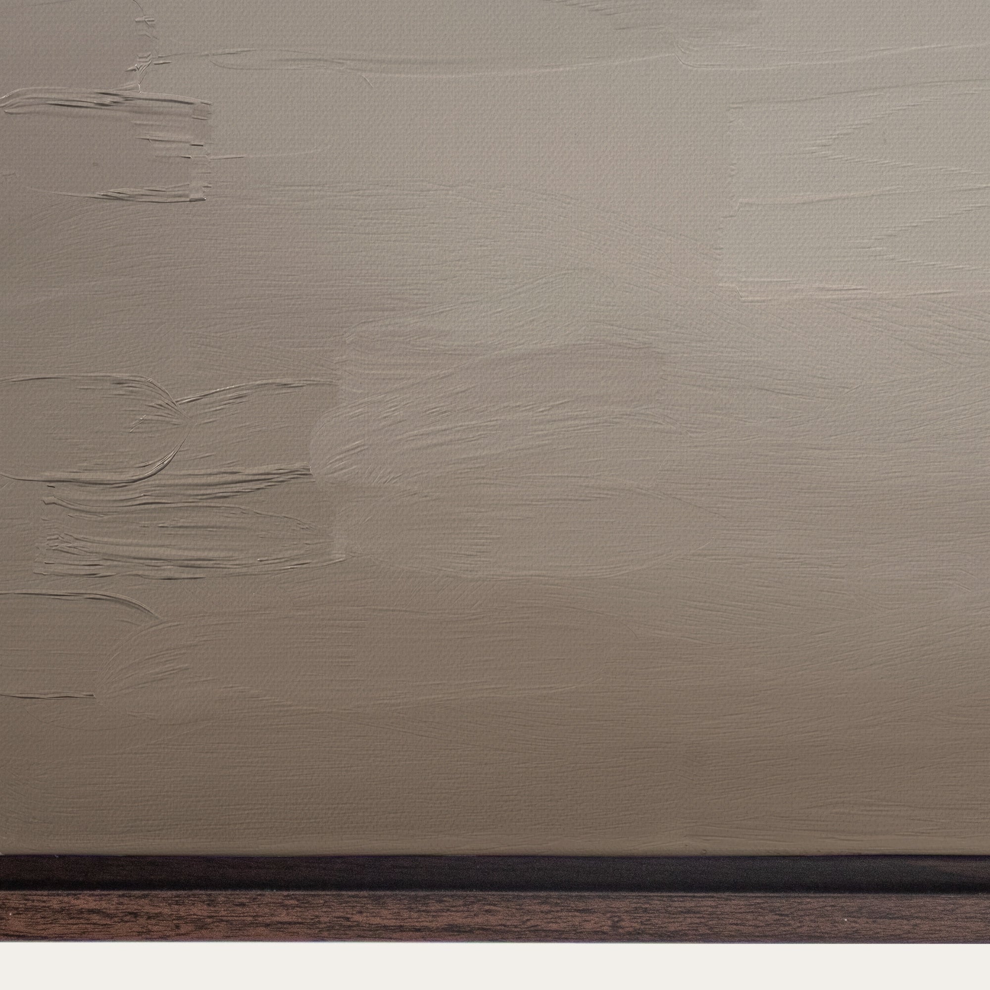 Textured beige wall with a dark brown baseboard 