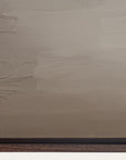 textured beige wall with a dark brown baseboard 
