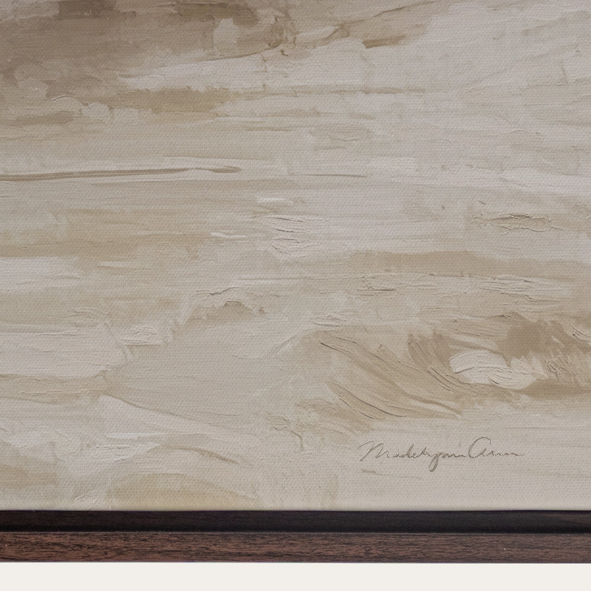 Close-up of a textured beige surface with a signature at the bottom right corner. 