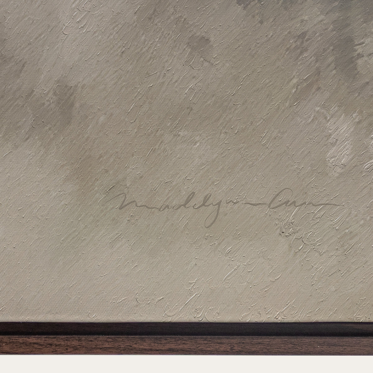 Textured beige surface with a signature and wooden border 