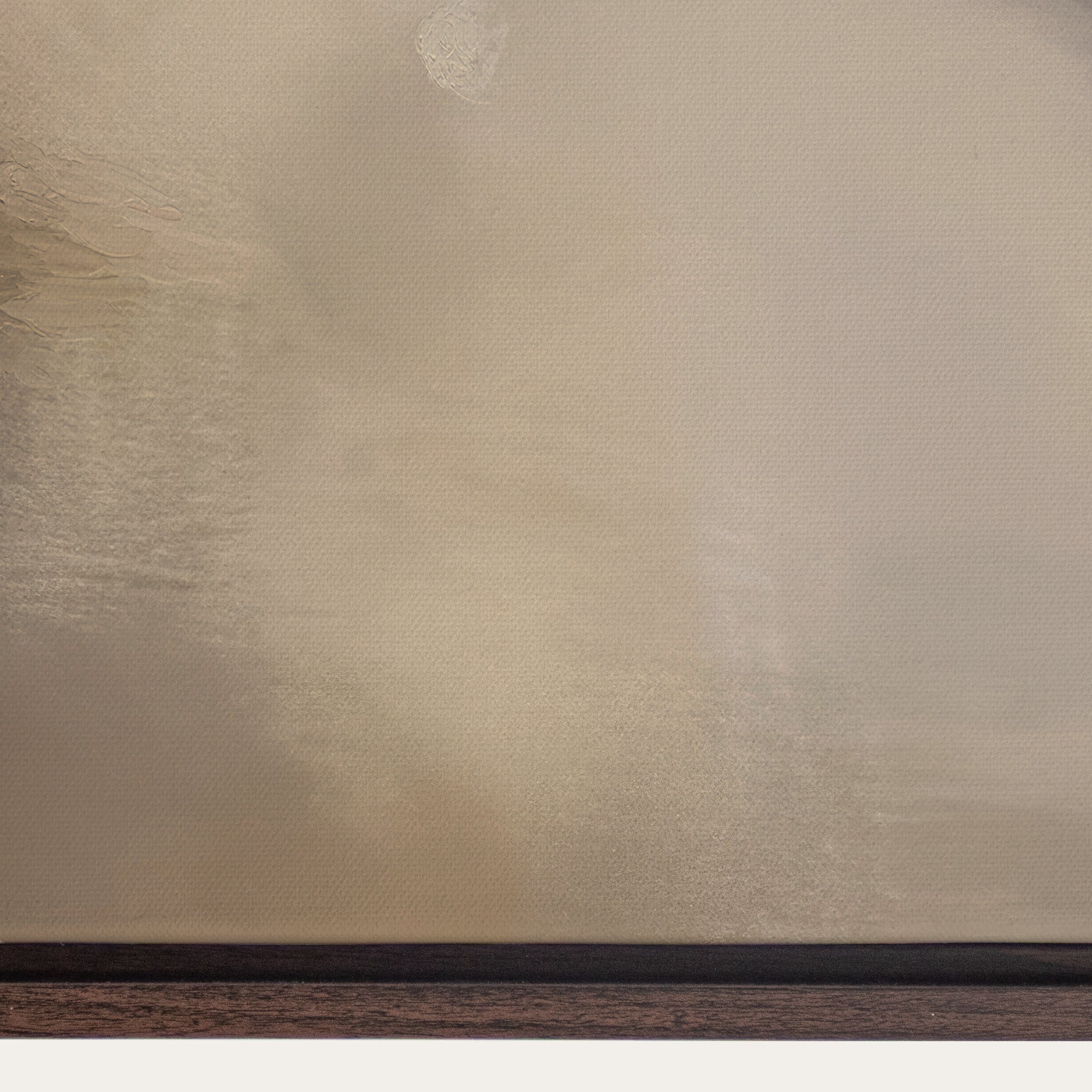 Textured beige wall with a dark wood baseboard 