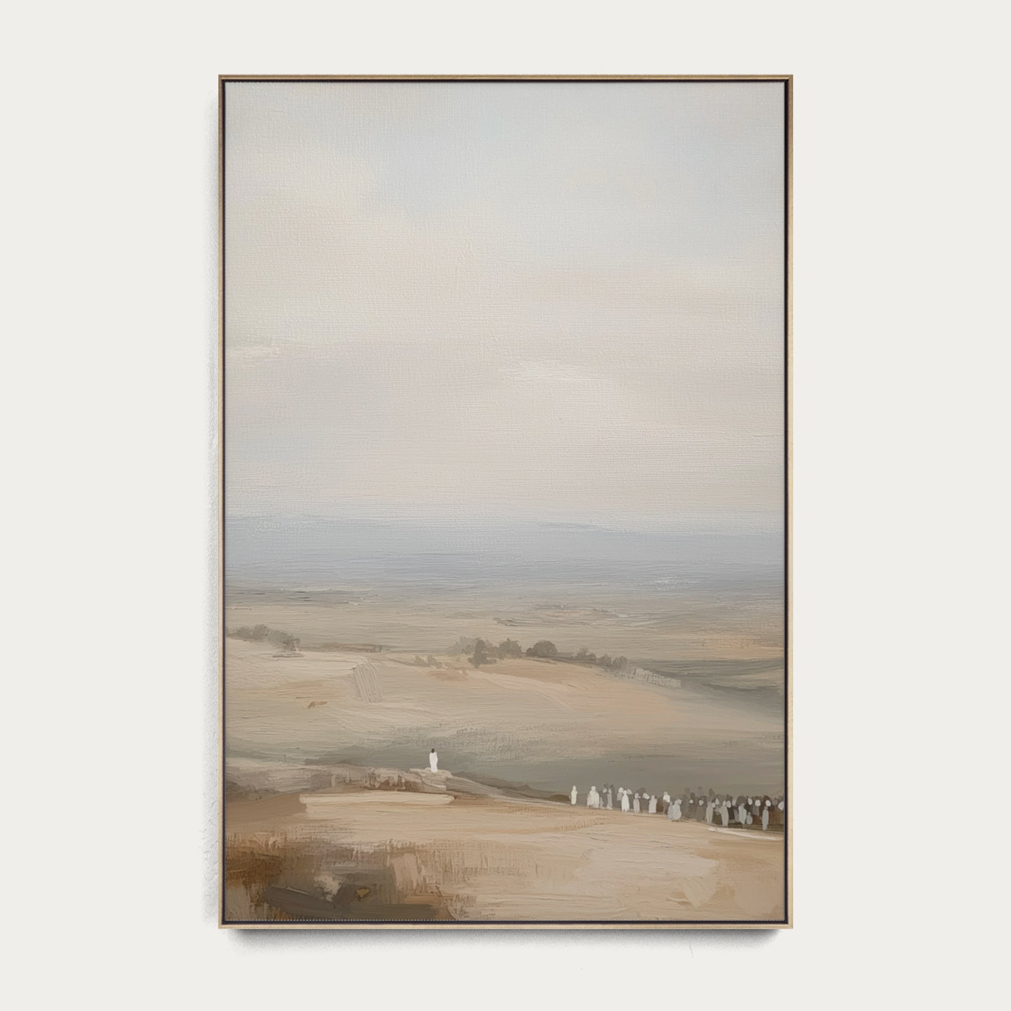 Framed landscape painting of a misty field with a white structure on a white wall. 