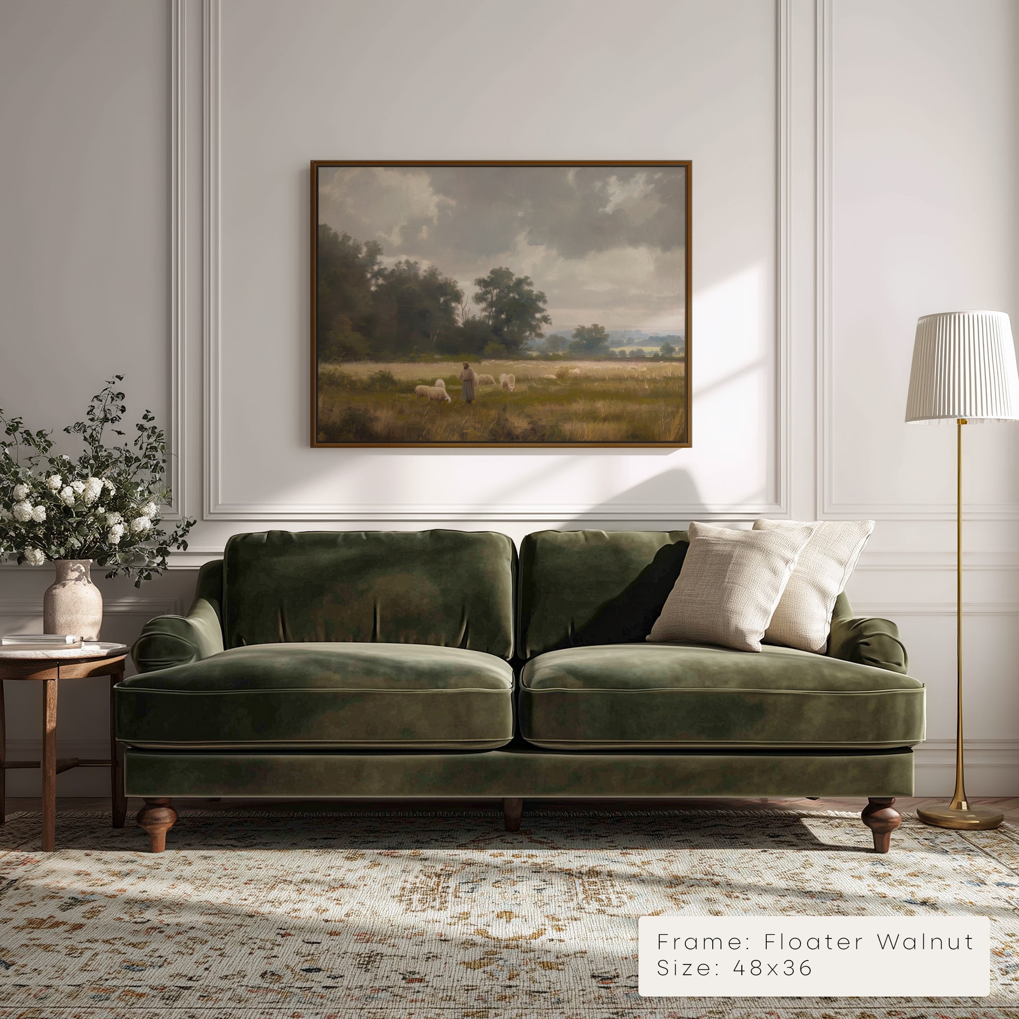 Green velvet sofa in a living room with a painting on the wall and a lamp.