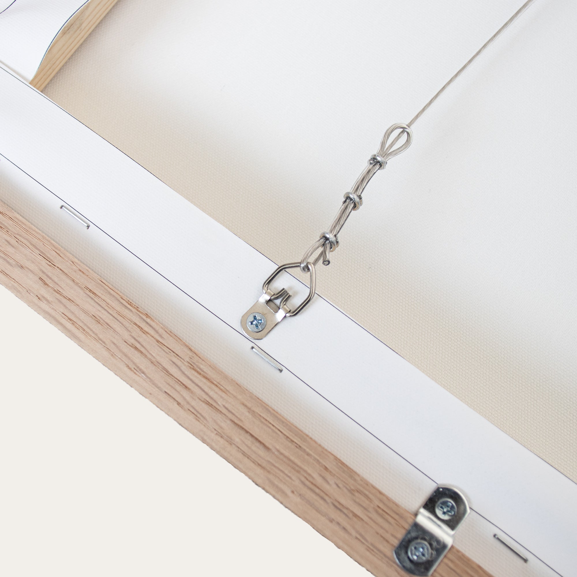 Close-up of a wooden frame with a metal hanging hook on a white background
