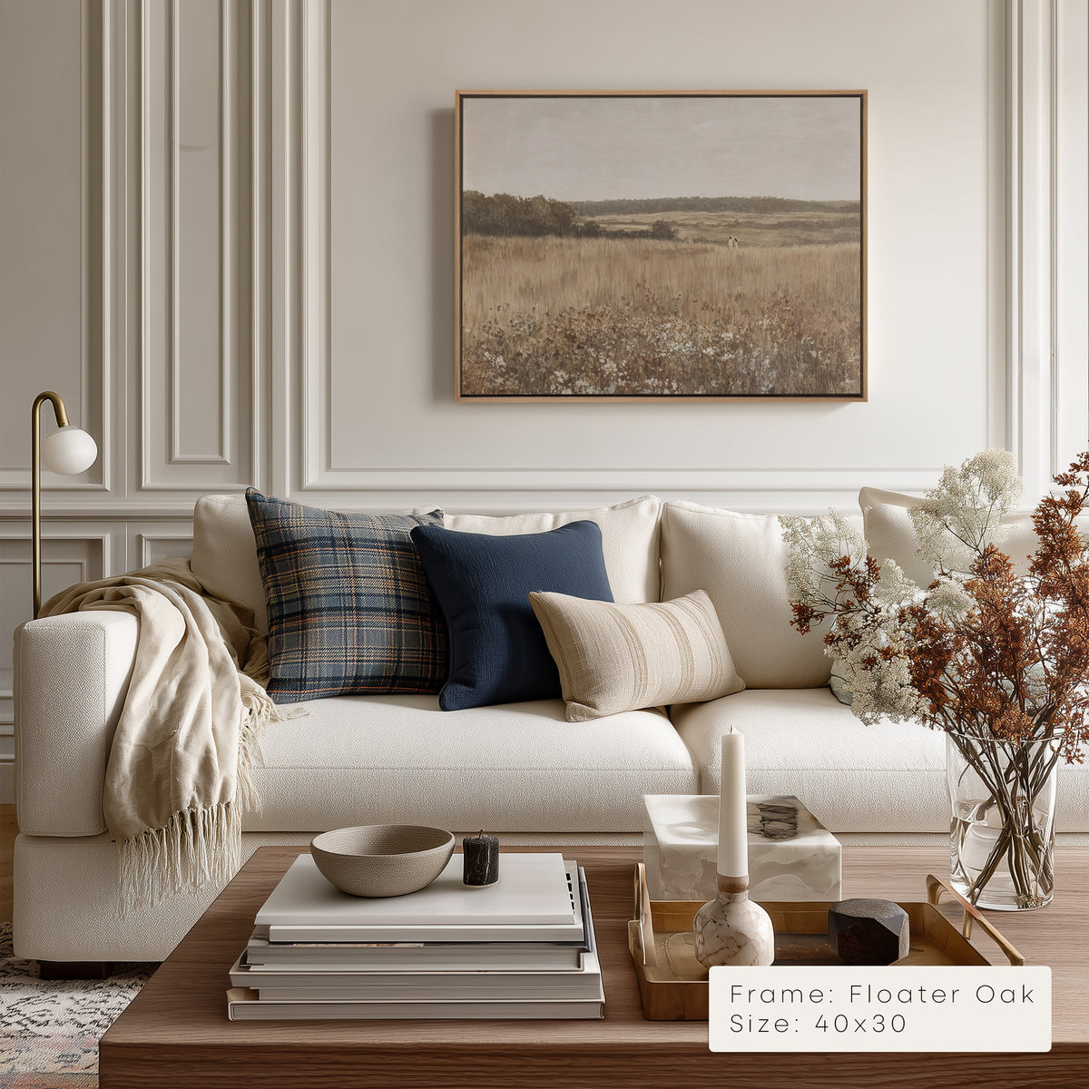Modern living room with a white sofa, decorative pillows, and a framed landscape painting on the wall.