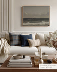 modern living room with a white sofa, decorative pillows, and a framed artwork on the wall.