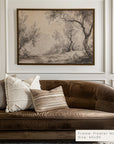 brown sofa with decorative pillows in a room with a framed landscape painting on the wall.