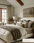 neatly made bed with pillows and blankets in a bedroom setting.
