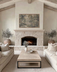 Living room with stone fireplace, beige sofas, and a coffee table.