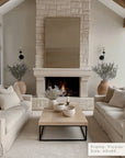 modern living room with stone fireplace, beige sofas, and decorative elements.