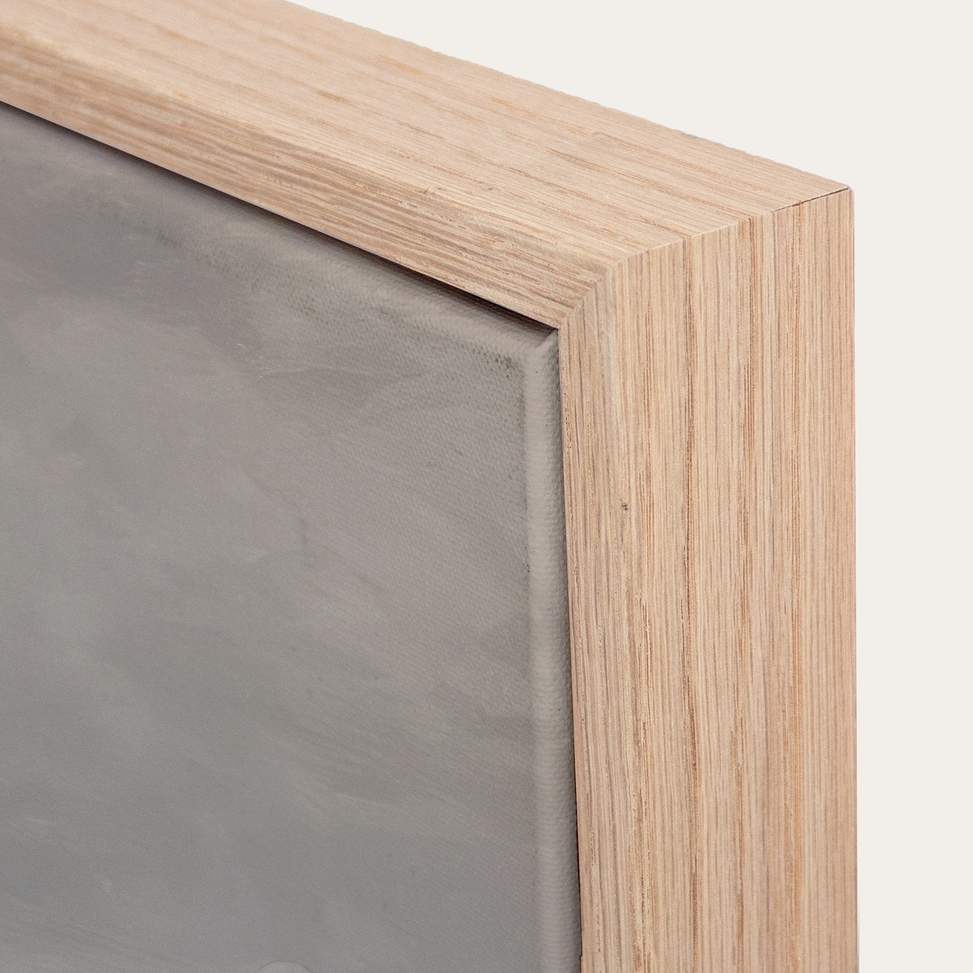 Close-up of a wooden frame corner with a gray background. 