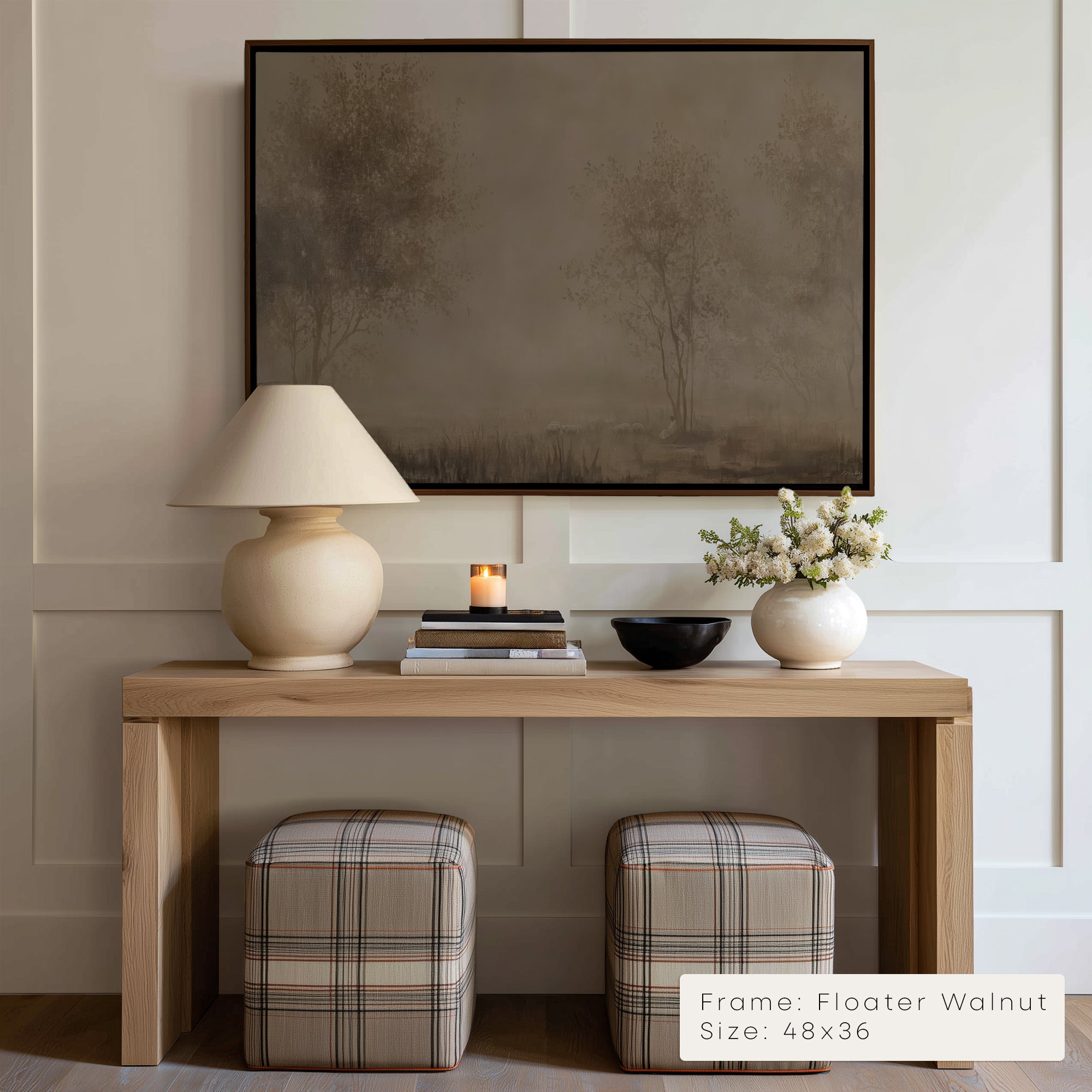 Wooden console table with lamp, books, and flowers against a wall with a framed abstract painting.