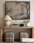 wooden console table with lamp, books, and decorative items against a wall with framed artwork.