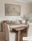 dining room with wooden table, chairs, and a framed artwork on the wall.