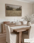 dining room with wooden table, chairs, and a painting on the wall.