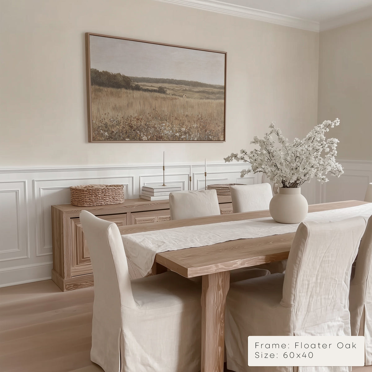 Dining room with wooden table, chairs, and a framed landscape painting on the wall.