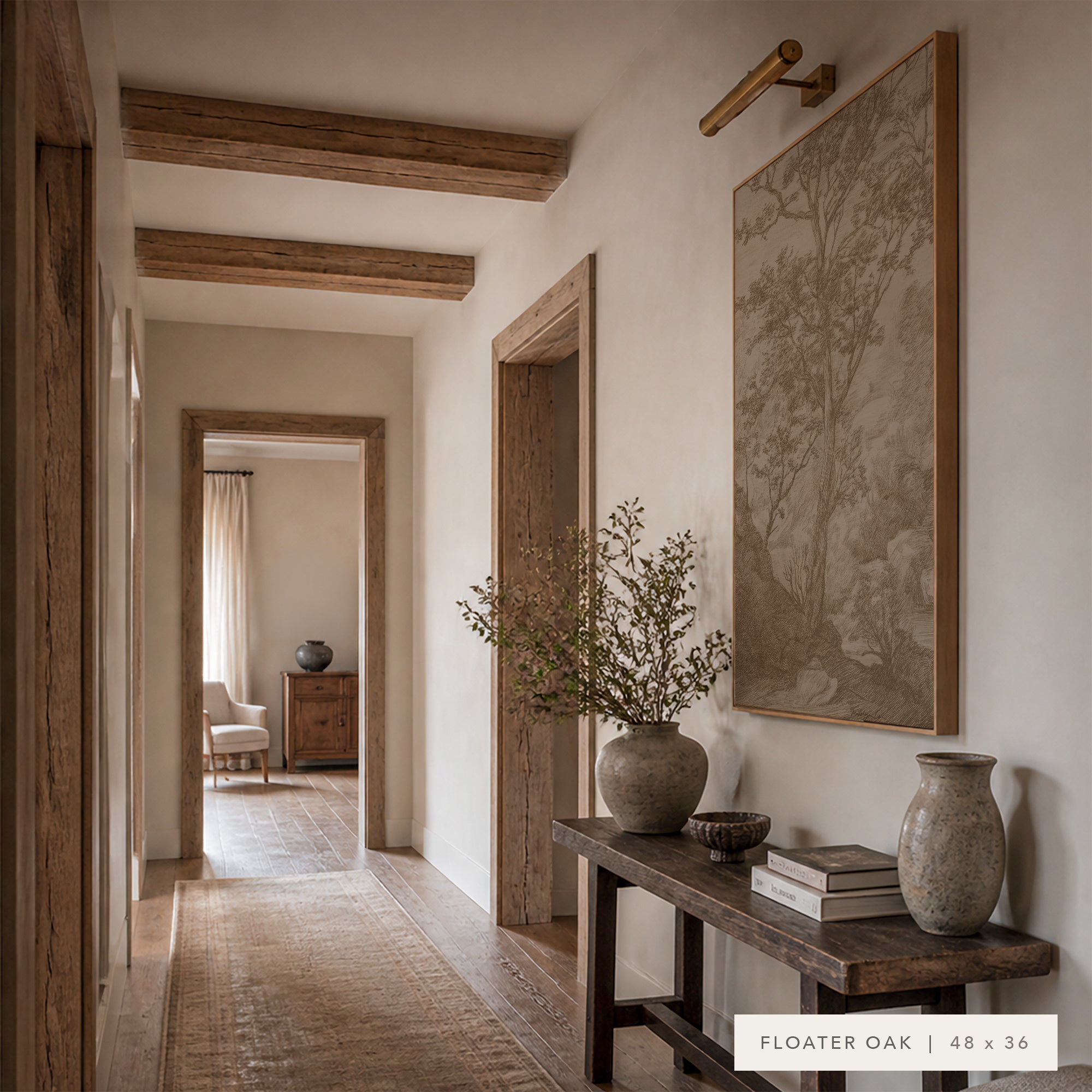 A large framed wall art print depicting a tree in muted floating oak tones, displayed in a rustic interior hallway above a dark wood console table with vases and books.