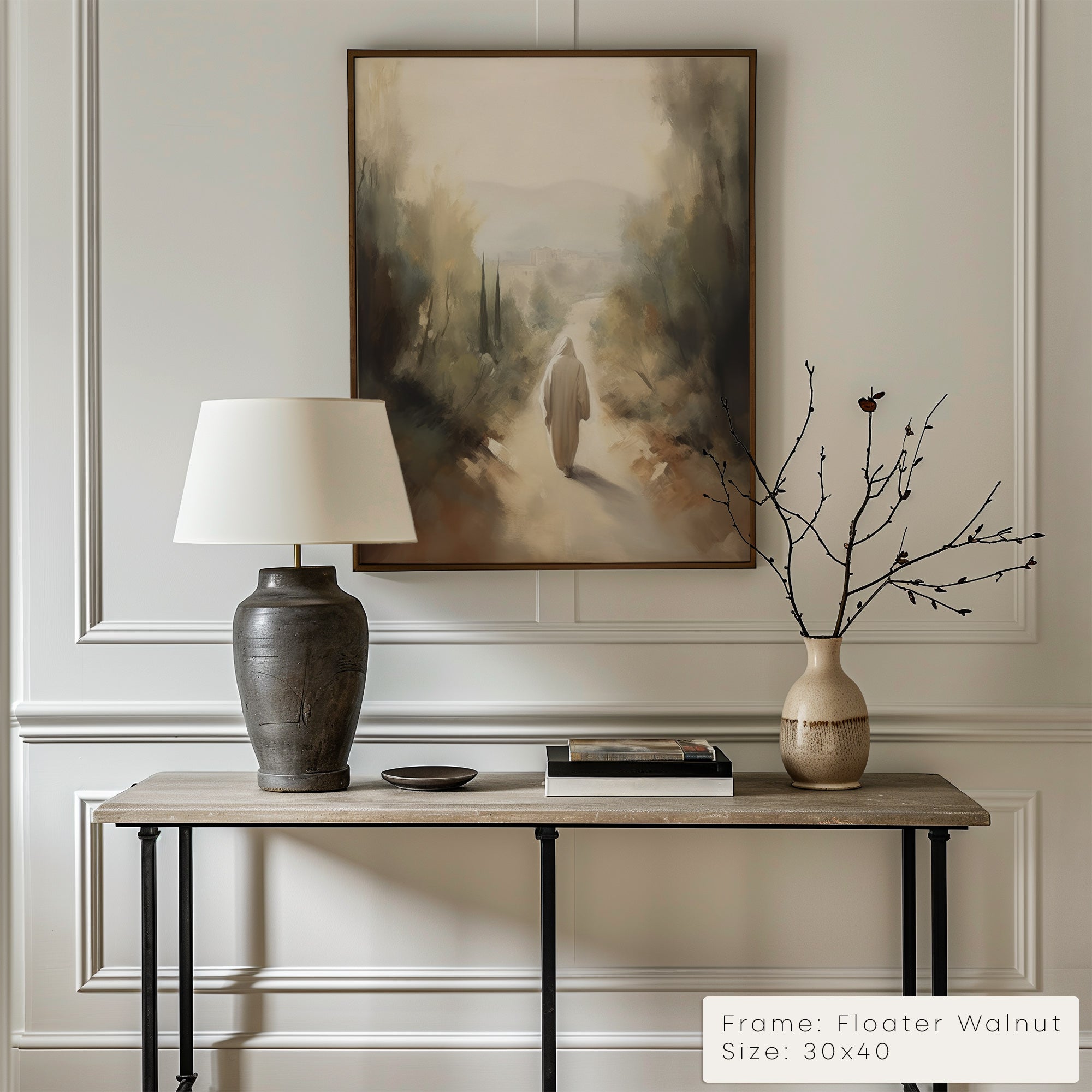 Decorative interior setting with a table, lamp, and vase against a wall with a painting.