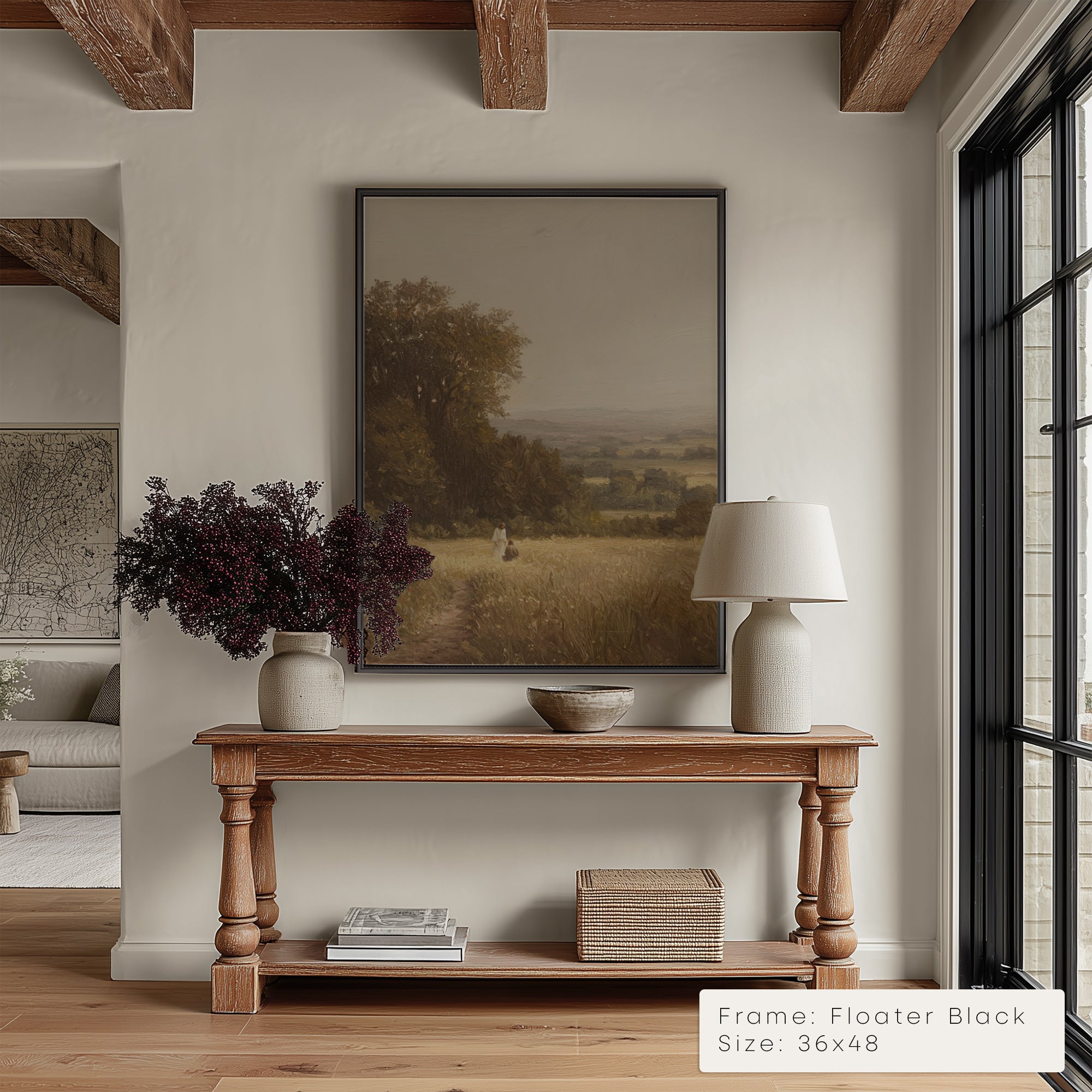 Living room with wooden console table, framed landscape painting, and decorative items.