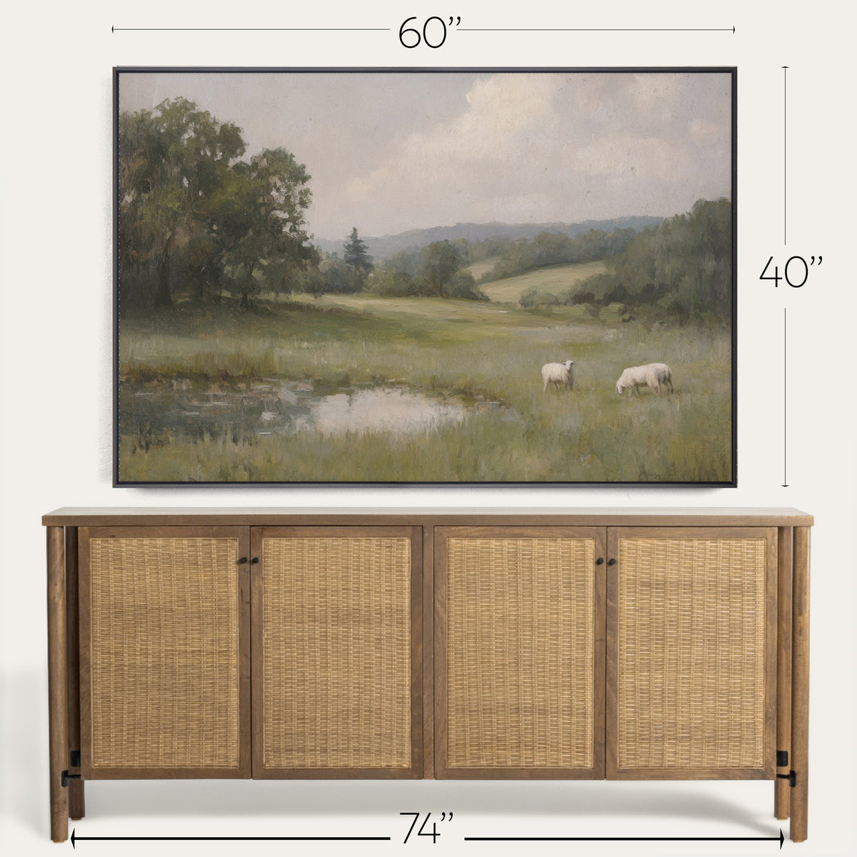Framed landscape painting of a field with sheep above a wooden cabinet. 