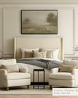 neatly decorated bedroom with a bed, armchairs, and a framed landscape painting.