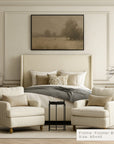 neatly decorated bedroom with a bed, armchairs, and framed artwork.