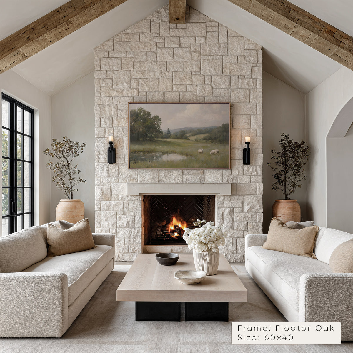 Living room with stone fireplace, white sofas, and a painting above the fireplace.