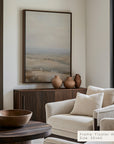 modern living room with a neutral color scheme, featuring a large landscape painting above a wooden console table.