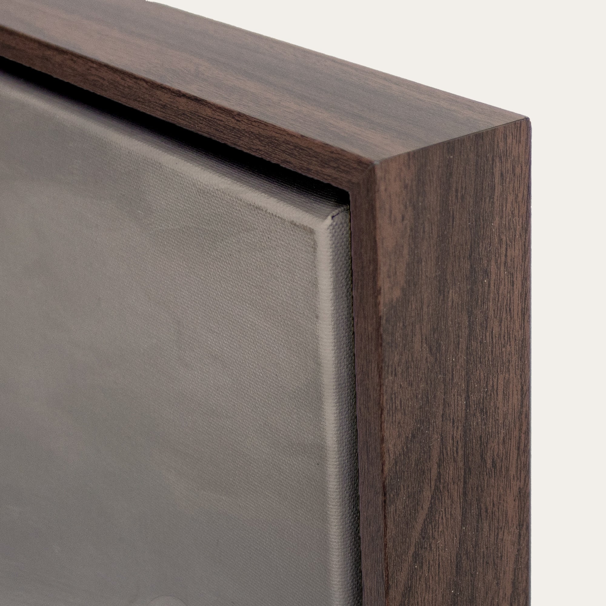 Close-up of a wooden frame corner with a metallic surface. 