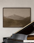white mountains in a dark walnut floater frame between white built-in shelves, above a black grand piano with its lid raised. shown in floater walnut, 60 x 40.