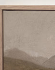 close-up of the top corner of white mountains in a light oak floater frame against a white wall, showing the canvas edge, fine age cracks across the sky, and a distant ridge below.