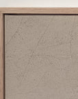 close-up of the top corner of the vertical white mountains print in a light oak floater frame against a white wall, showing the canvas edge and fine age cracks across the sepia sky.